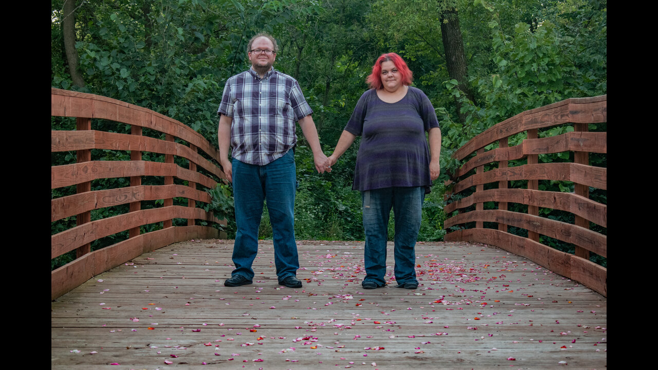 Alex and Danni holding hands in center of bridge.