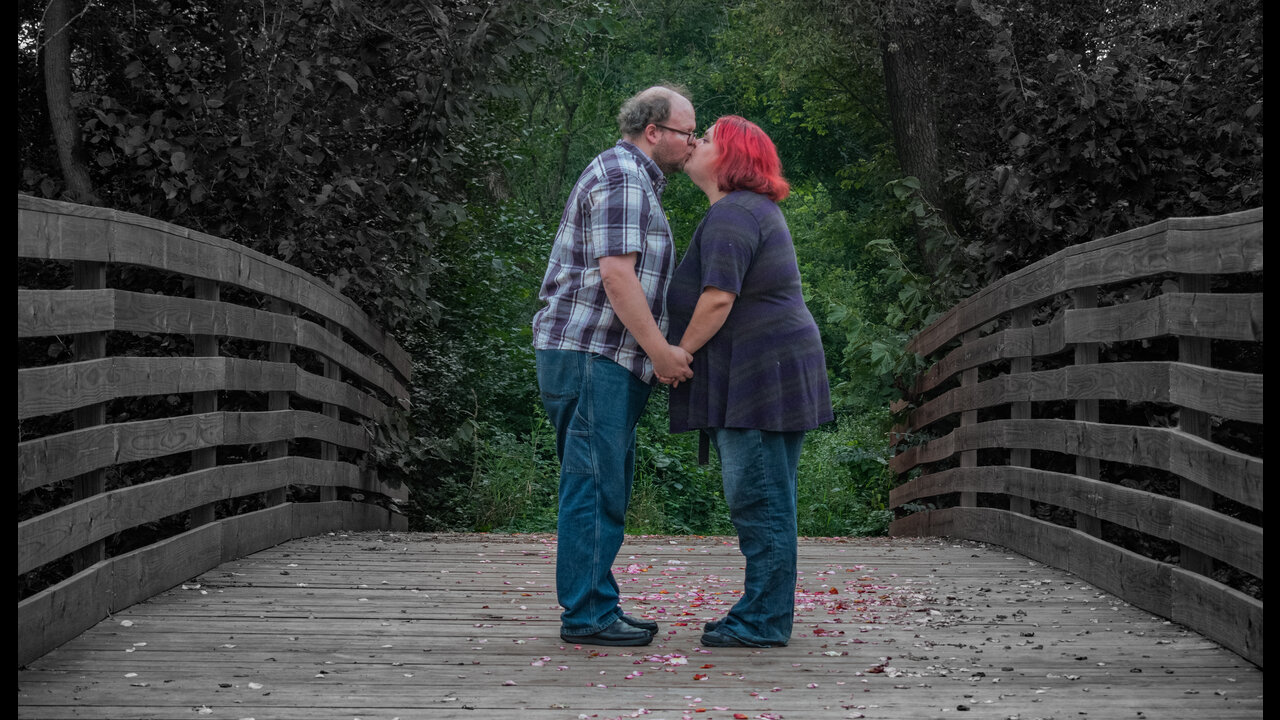 Alex and Danni kissing in center of bridge.