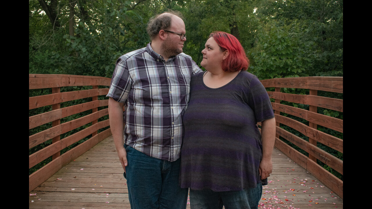 Alex and Danni looking into eachother's eyes in center of bridge.