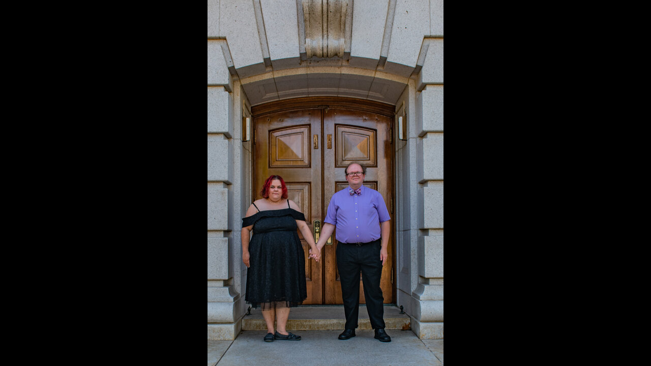 Danni and Alex holding hands in front of doorway at Wisconsin State Capitol.