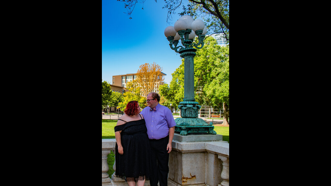Danni and Alex looking into eachother's eyes next to lamp post at Wisconsin State Capitol.